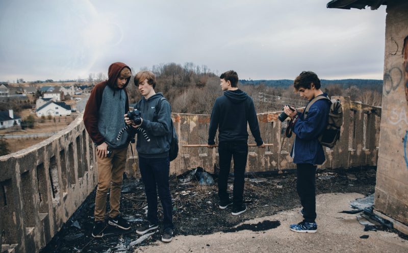 A group of young photographers standing on a bridge with cameras