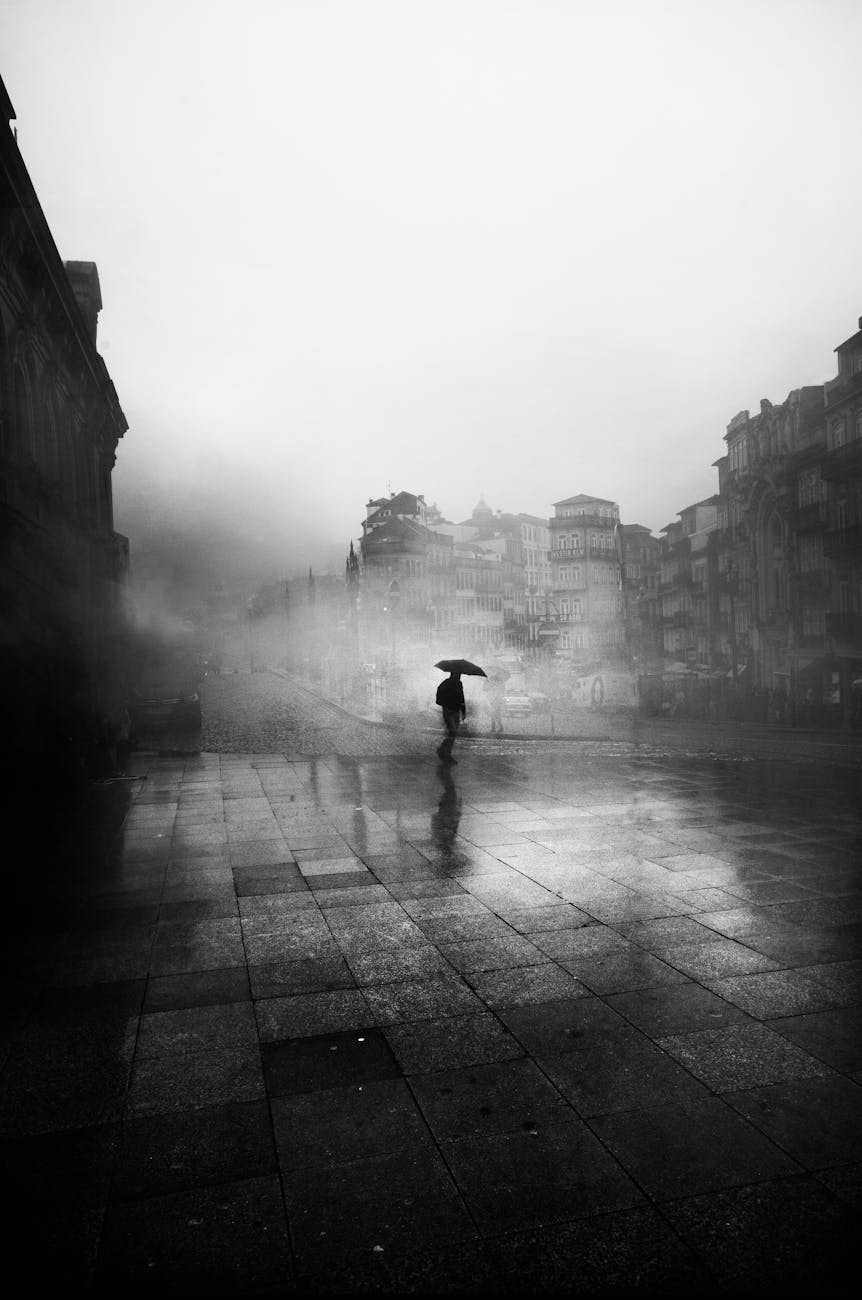 a man holding an umbrella on a dark and misty street
