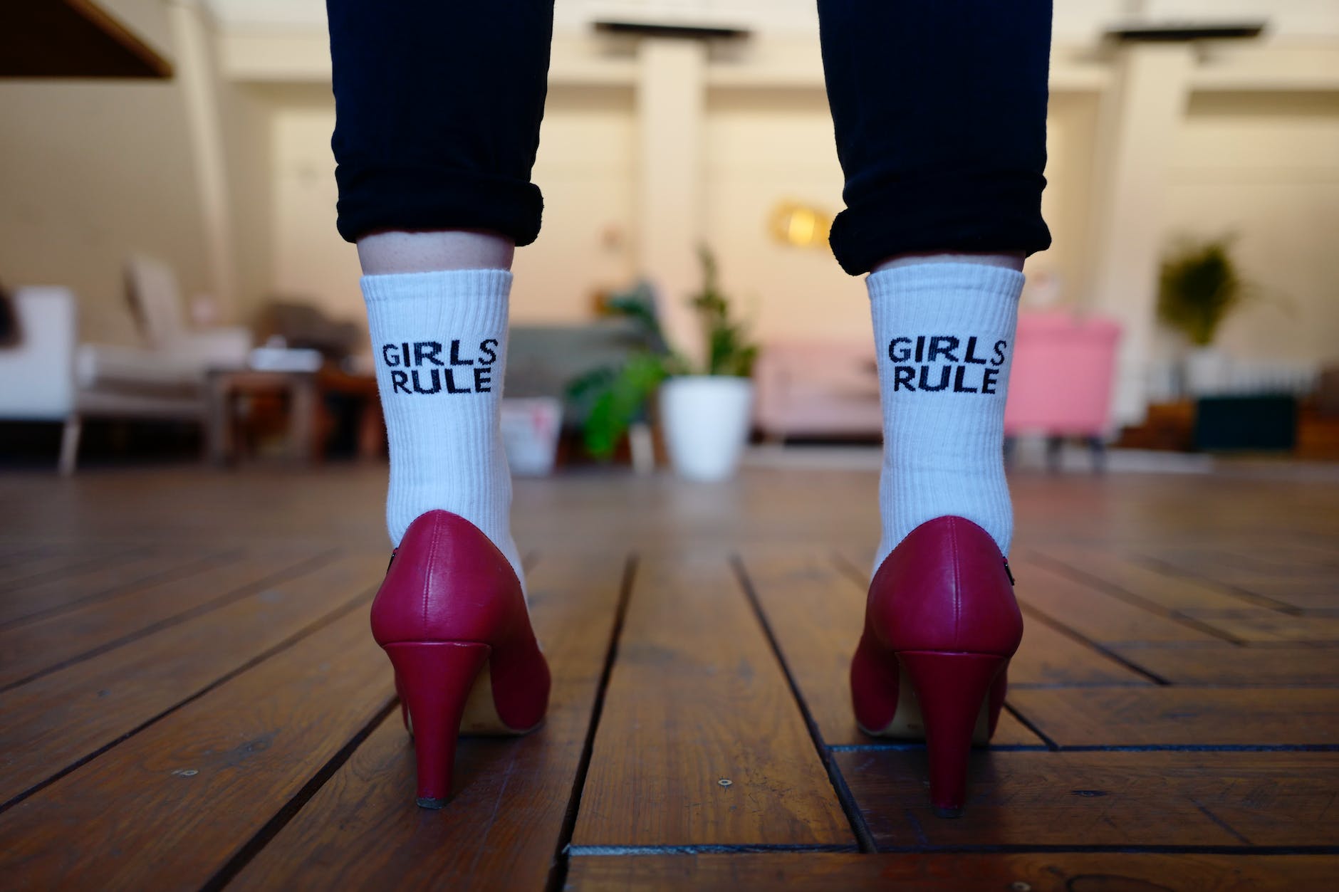 pair of legs wearing white socks reading girls rule with pink heel shoes
