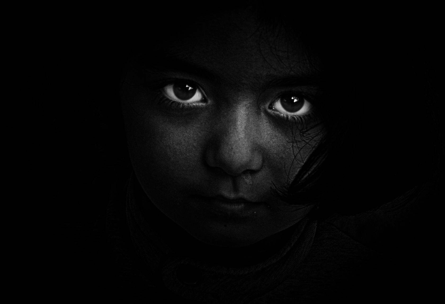 eyes of a child in the dark in black and white