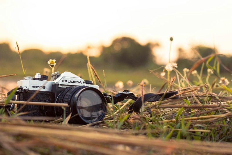 fujica film camera placed on the grass at golden hour