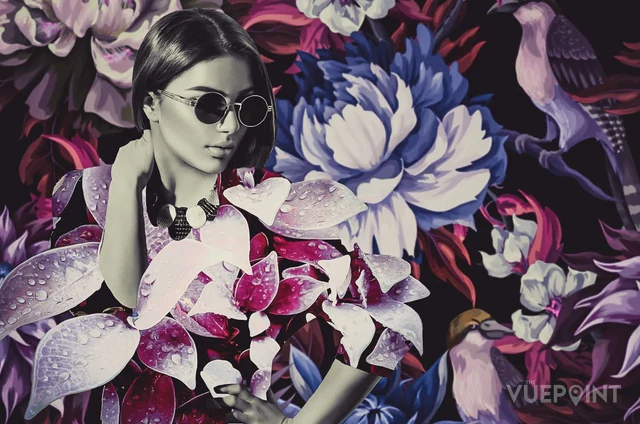 A portrait set among oversized purple and white petals