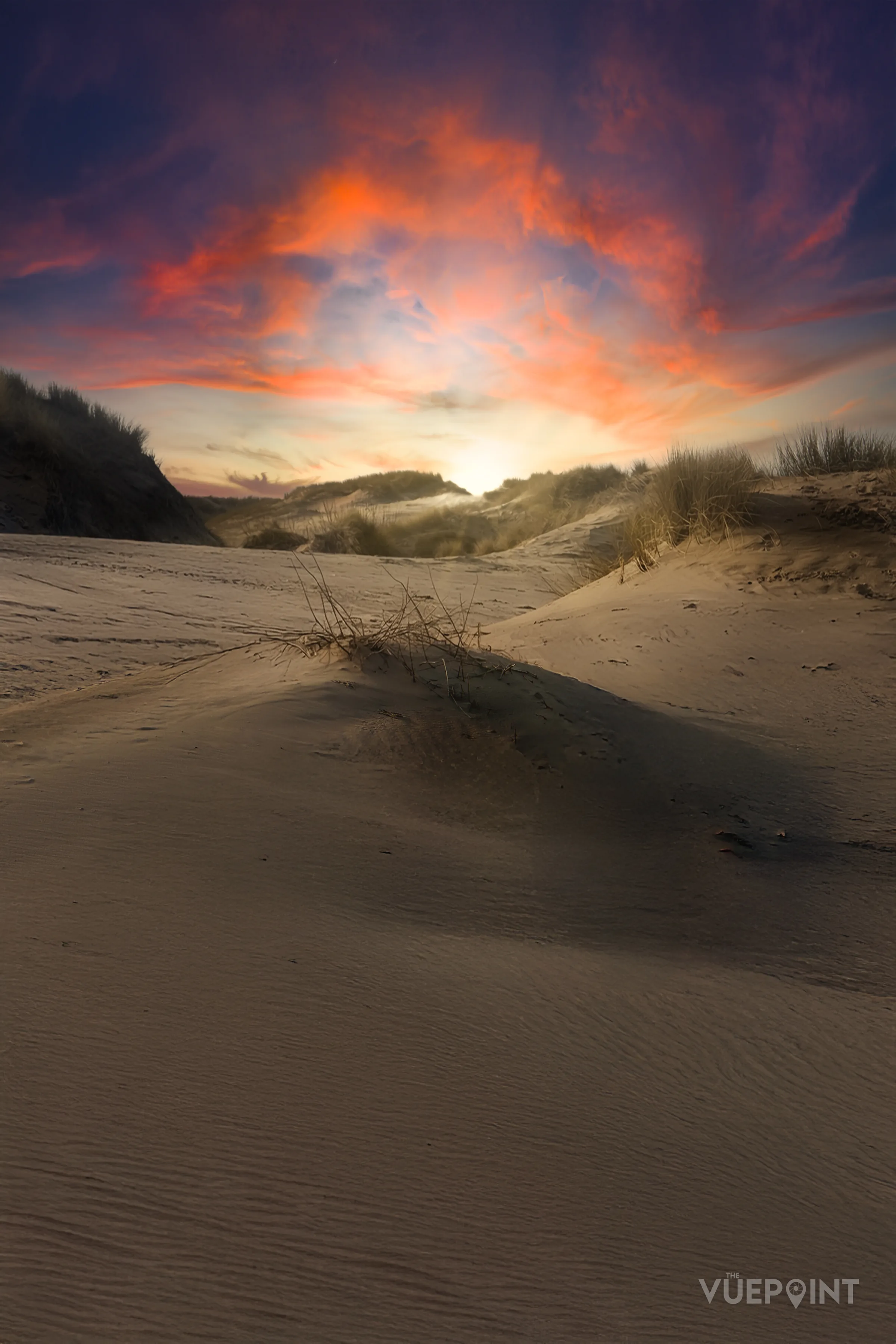 Red cloud over sand dunes at first light