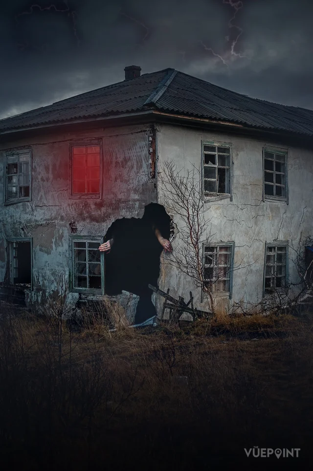 A derelict house at dusk with a figure at the door