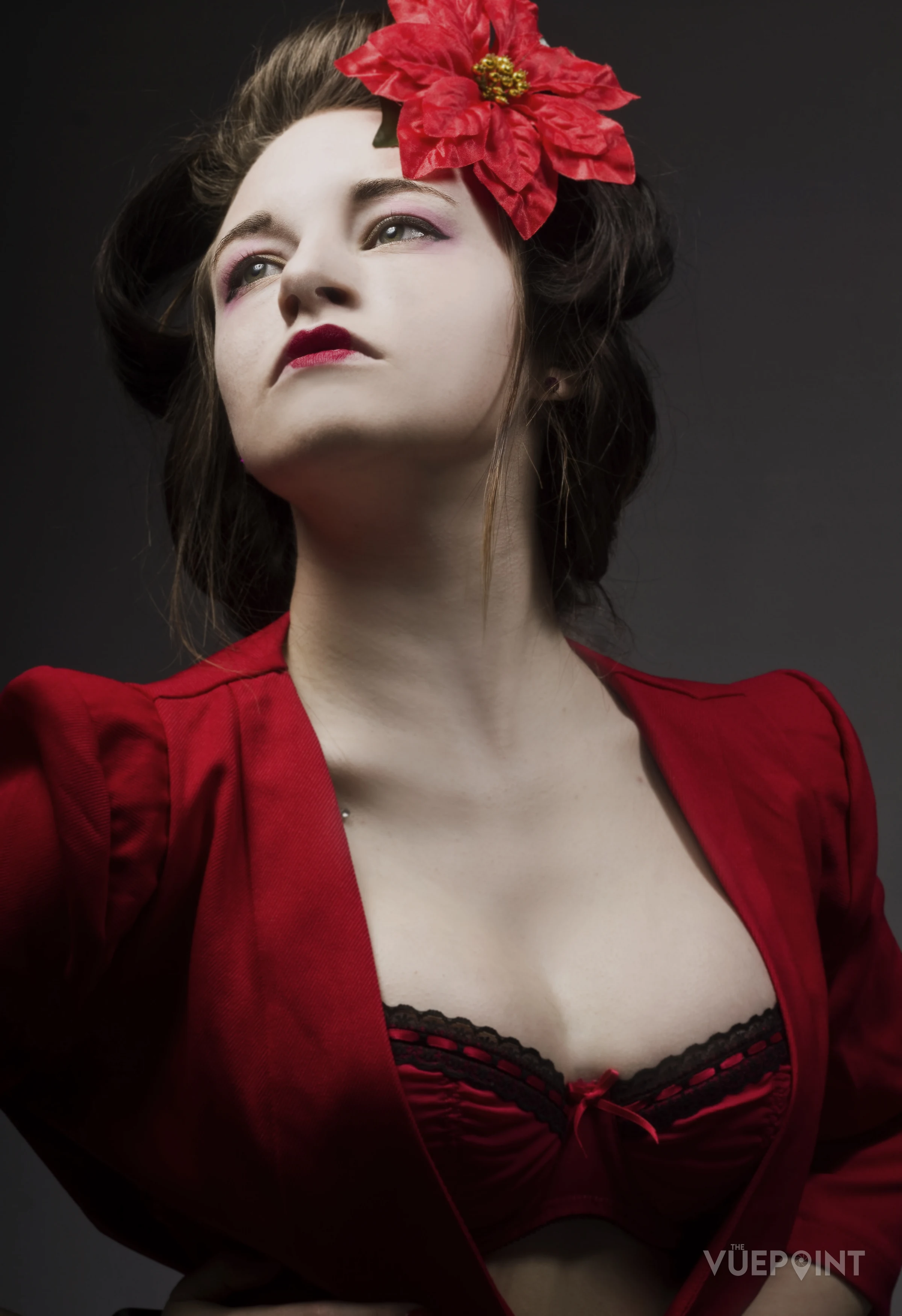 A woman in a red jacket with a red flower in her hair