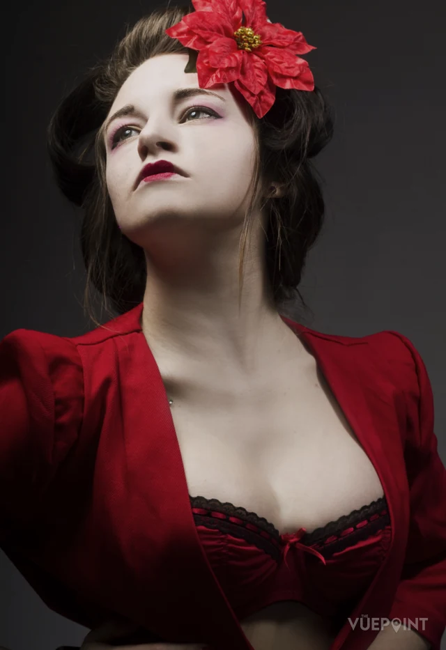A woman in a red jacket with a red flower in her hair