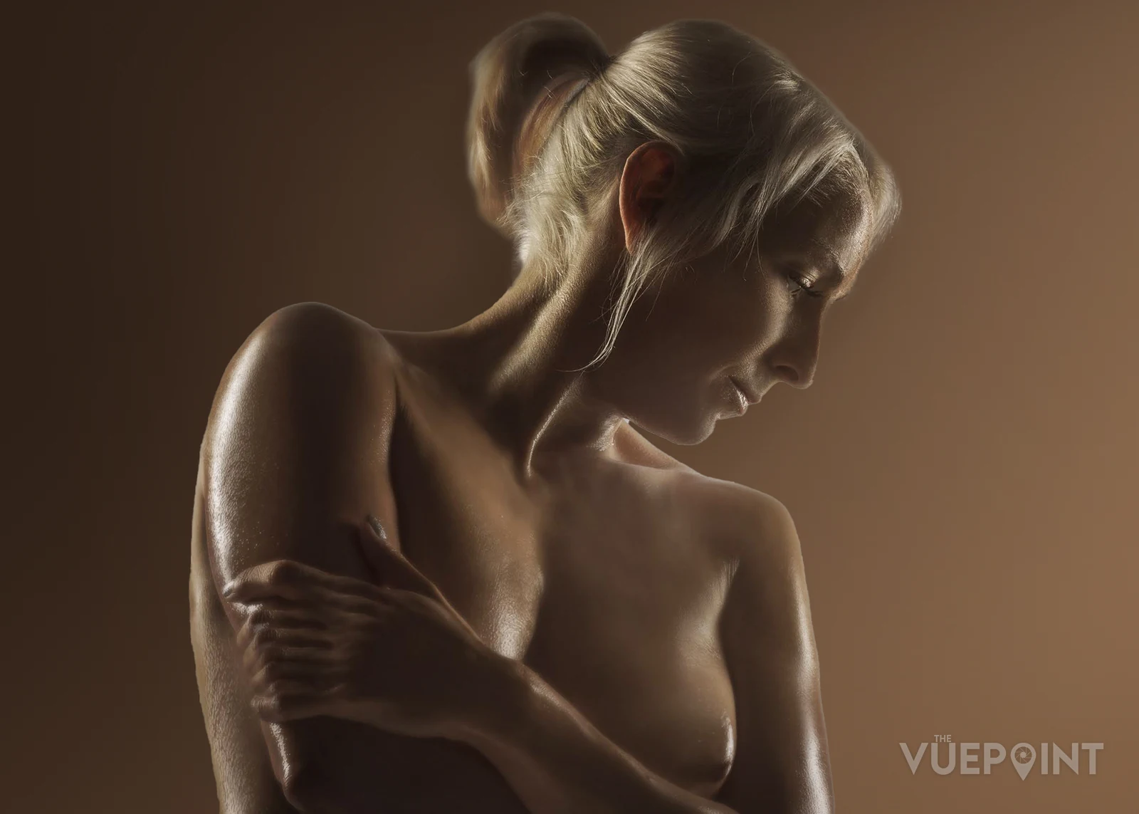 A warm-toned studio study, the figure turned away from the camera