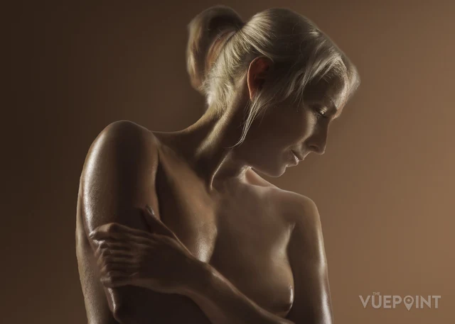 A warm-toned studio study, the figure turned away from the camera