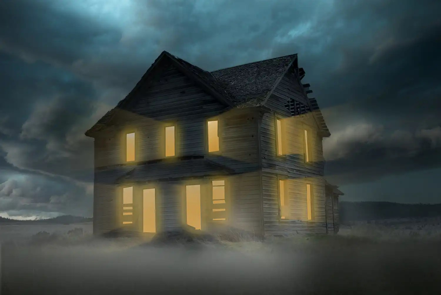 an old abandoned house with yellow lights shining out of it with mist surrounding the floor