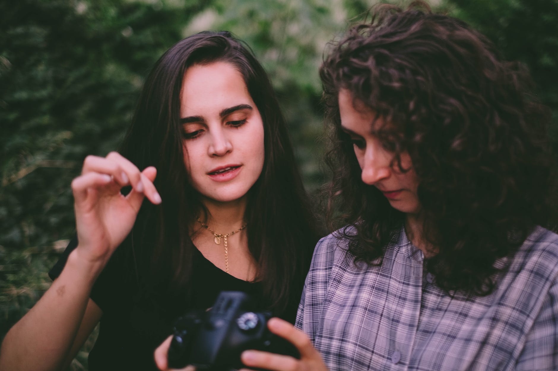 A woman teaching another woman how to use a digital camera