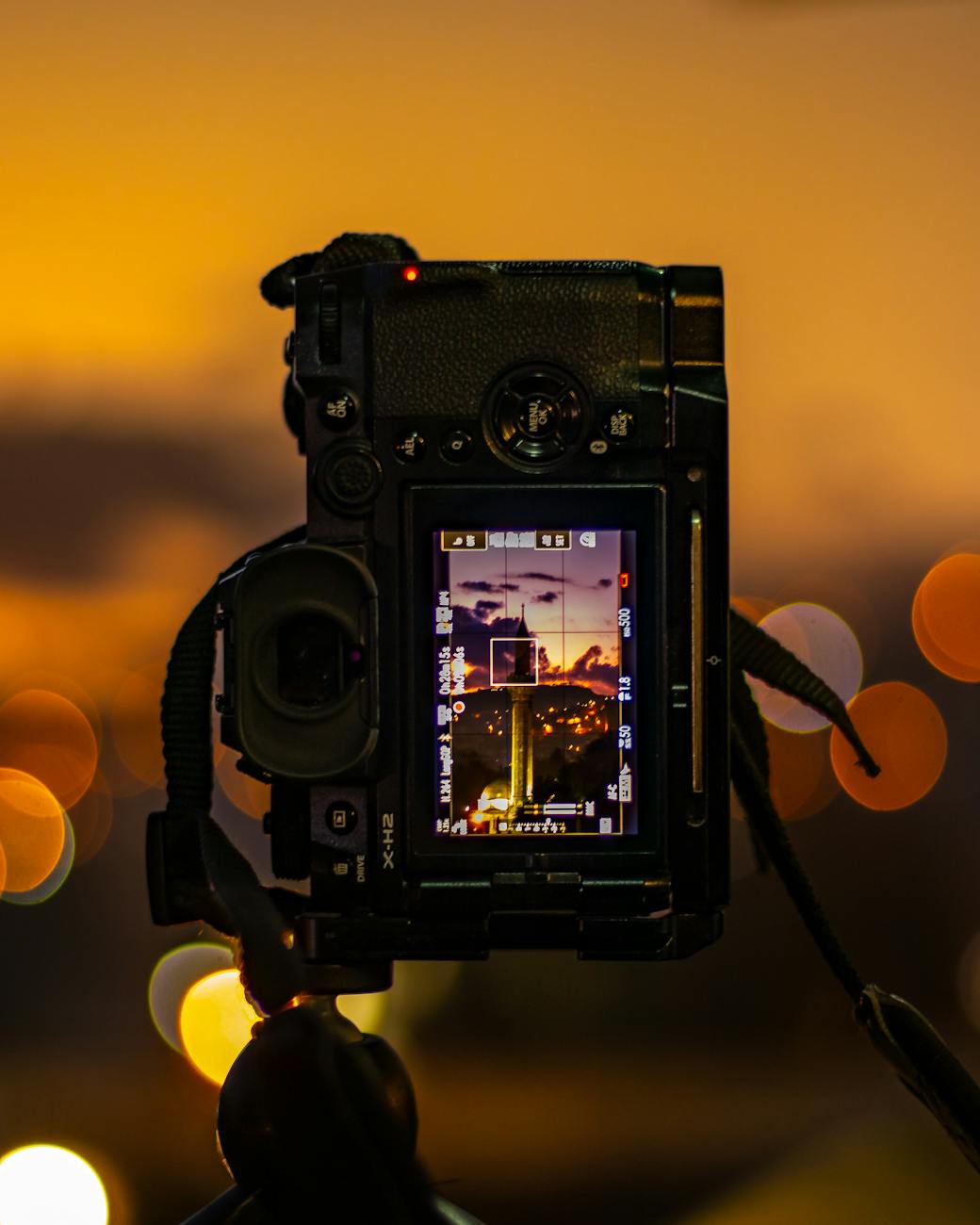 back of a digital camera with city scene at night on the screen