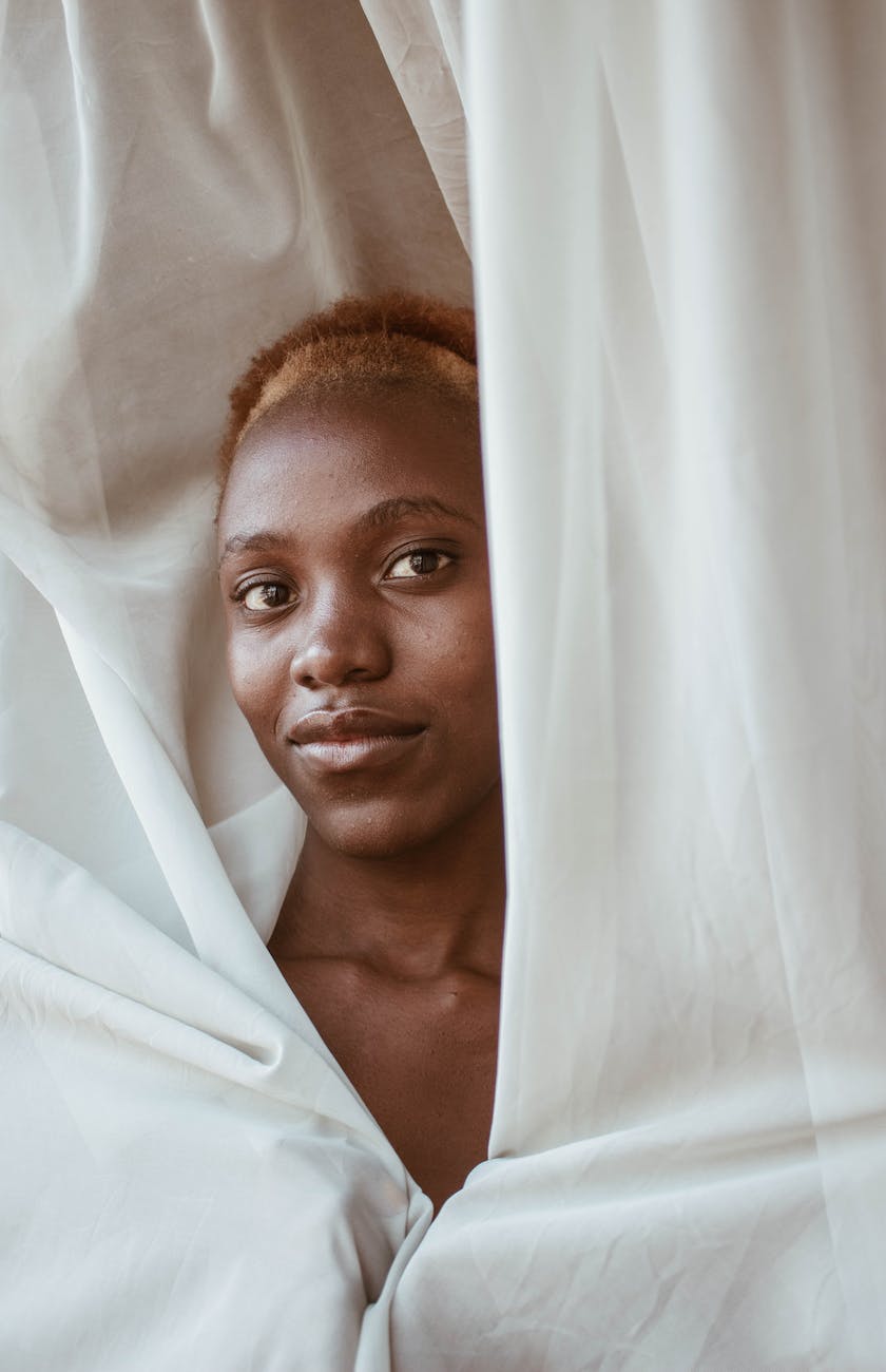 a black woman smiling wrapped in a white sheet