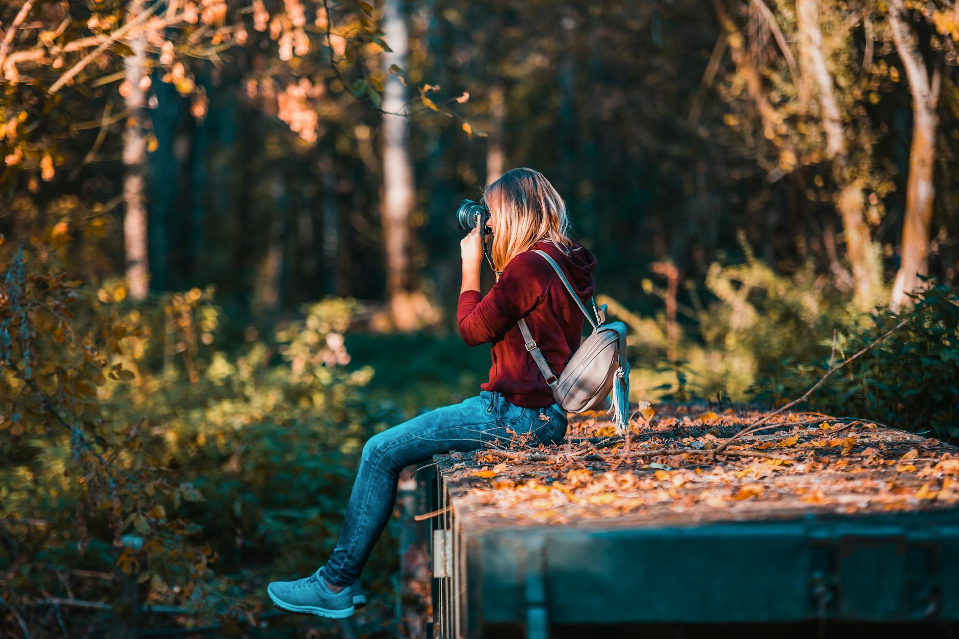 a lady with a camera out in the forest