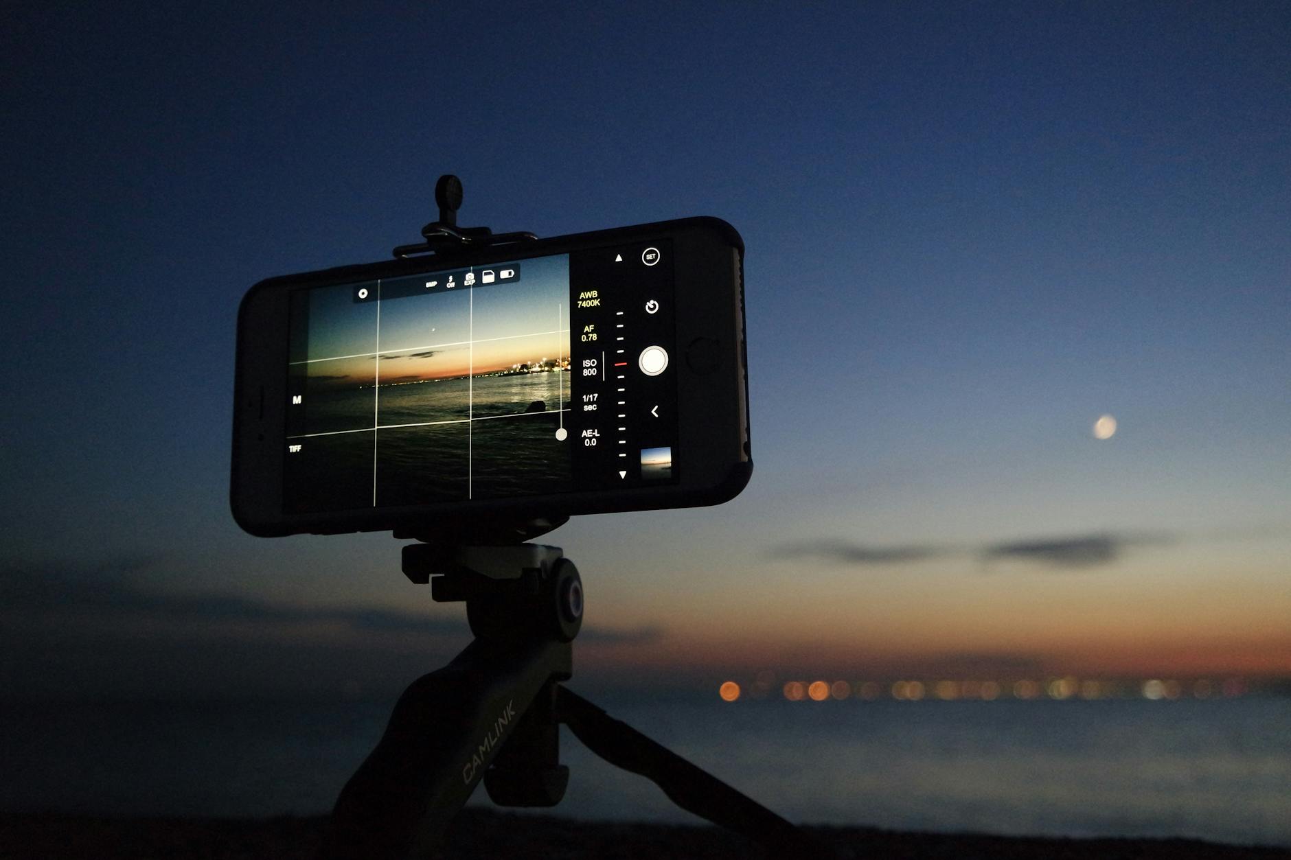 iPhone on a tripod taking a photo of the sea at night